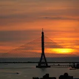 Una hermosa puesta de sol detrás del puente del río Tamsui, en Nuevo Taipéi, Taiwán, con cálidos tonos anaranjados.
