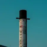 Toma vertical de una torre de cohetes de SpaceX contra el cielo azul en Dubái, Emiratos Árabes Unidos.