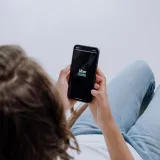 Vista desde arriba de una persona usando la aplicación Uber Eats en un teléfono inteligente, que muestra la integración de tecnología moderna.