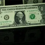 Primer plano detallado de un billete de un dólar estadounidense con reflejo, que destaca el diseño de la moneda.