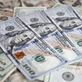 Un primer plano detallado de varios billetes de dólar estadounidense dispuestos de forma dispersa.