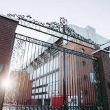 A photo capturing the iconic gates of Anfield Stadium, Liverpool, with sunrays illuminating the architecture.