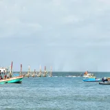 Scenic view of traditional fishing boats at Ong Dung Beach, Vietnam, under a bright sky.