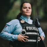 Retrato de una agente de policía segura de sí misma, vestida con uniforme al aire libre.