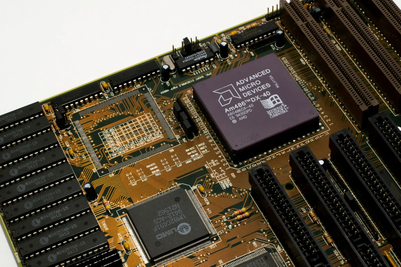Vista detallada de una placa base antigua con un microchip AMD, que muestra circuitos y ranuras intrincados.