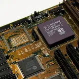 Vista detallada de una placa base antigua con un microchip AMD, que muestra circuitos y ranuras intrincados.