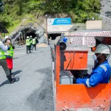 Trabajadores en una mina a cielo abierto, con énfasis en la seguridad del transporte ferroviario.