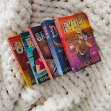 A vibrant collection of romance novels by Jessica Peterson resting on a plush white blanket, creating a cozy reading vibe.