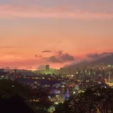 Una vista impresionante del horizonte de Caracas al atardecer, con un vibrante fondo de puesta de sol.
