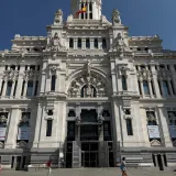 Vista frontal del icónico Palacio de Cibeles bajo un cielo azul despejado en Madrid, España.