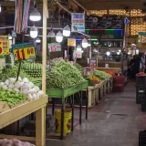 Un colorido y bullicioso mercado interior en la Ciudad de México, con puestos de productos frescos.