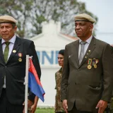 Veteranos condecorados por su servicio permanecen solemnemente en una ceremonia militar al aire libre.