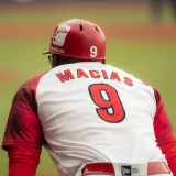 Jugador de béisbol en acción, con una camiseta con el número 9, en el campo.
