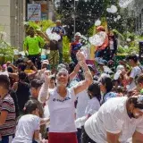 People enjoying a lively foam festival on a sunny day in Venezuela. Vibrant community celebration.