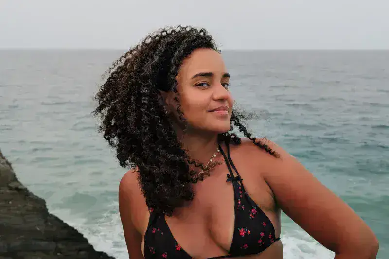 Woman smiling at the camera by the ocean in Cuyagua, Aragua, Venezuela, on a summer day.