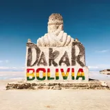 Stone monument at Salar de Uyuni celebrating the Dakar Rally in Bolivia's remote desert landscape.