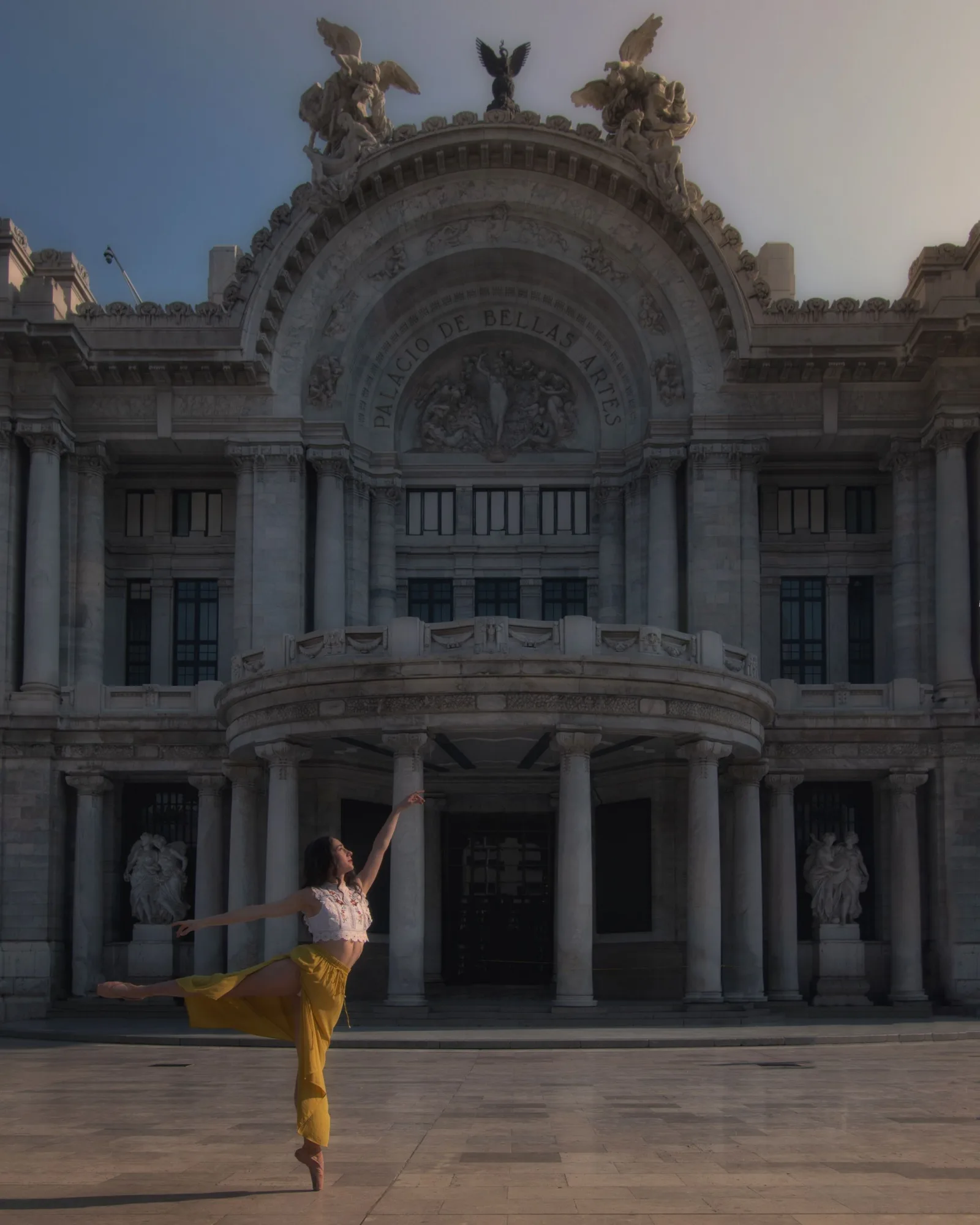 Ballet dancer posing gracefully at Palacio de Bellas Artes in Mexico City.