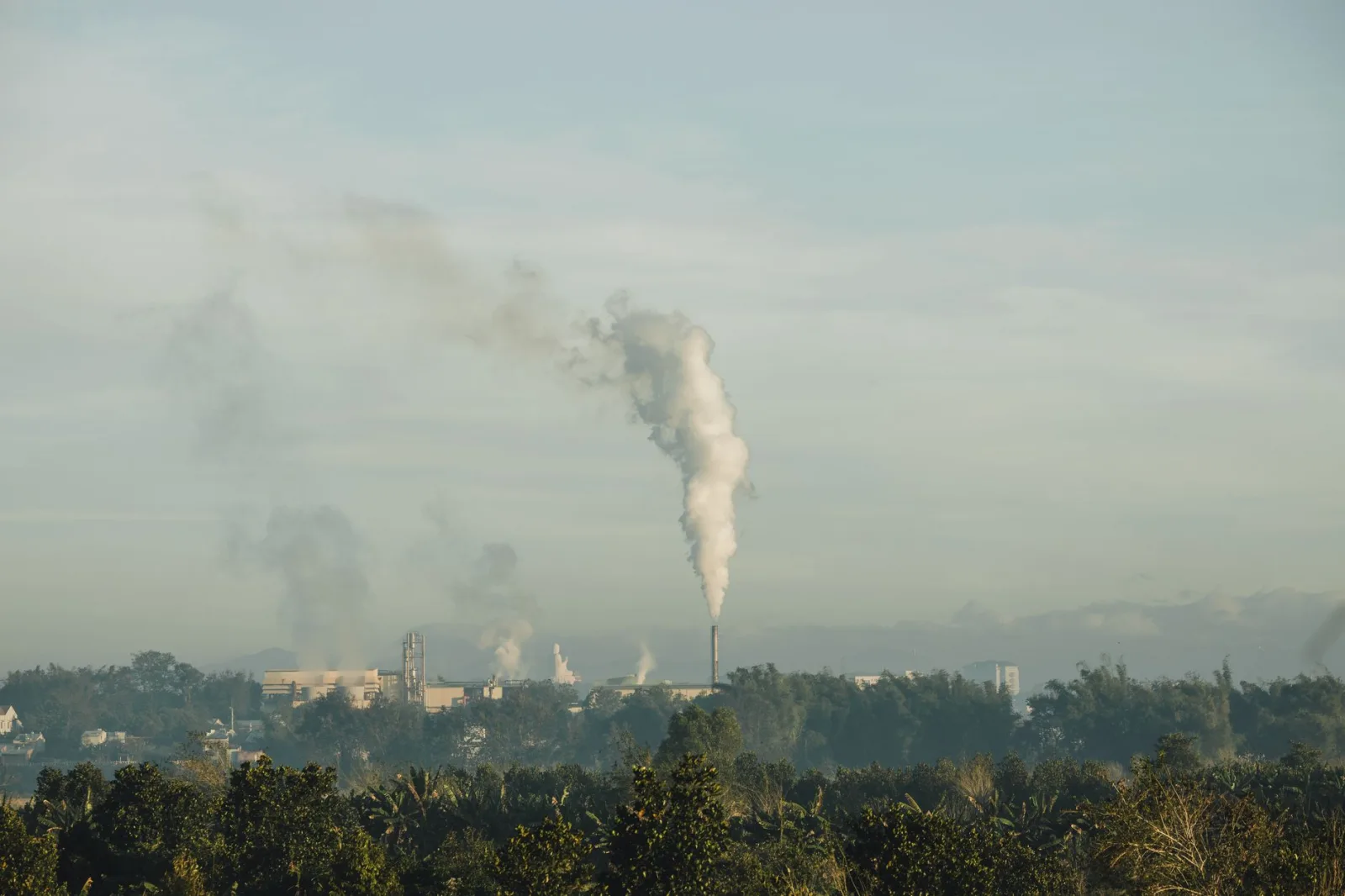 Una chimenea industrial libera emisiones al cielo sobre Kon Tum, Vietnam, y pone de relieve el impacto de la industria.