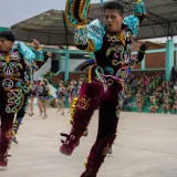 Energetic dancers in colorful traditional clothing performing at a festival in Imperial, Perú.