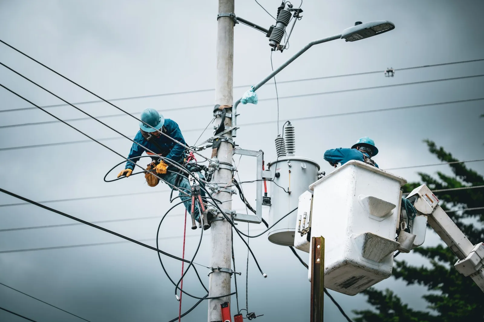 Electricians in San José, Costa Rica, repairing power lines from a cherry picker.