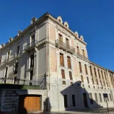 Elegant palace facade in Jaén, Spain, showcasing classic architectural style under a clear blue sky.