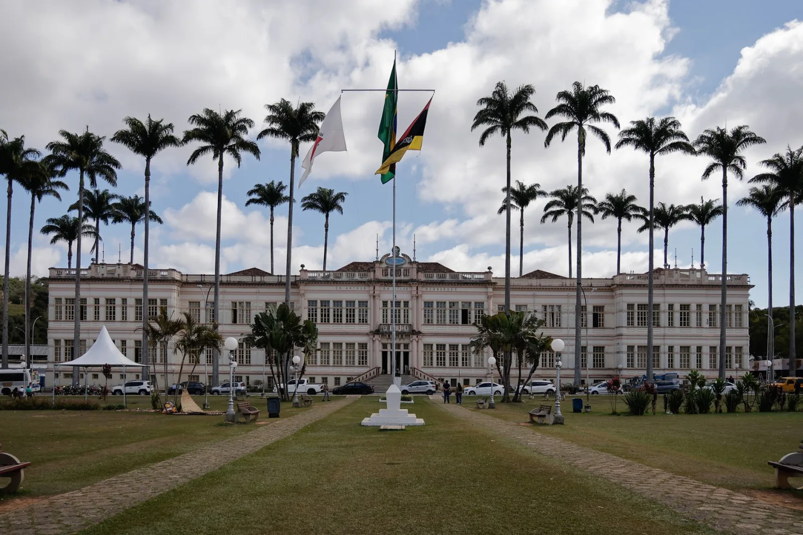 Elegant municipal building in Juiz de Fora, Brazil, surrounded by palm trees under a cloudy sky.