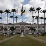 Elegant municipal building in Juiz de Fora, Brazil, surrounded by palm trees under a cloudy sky.