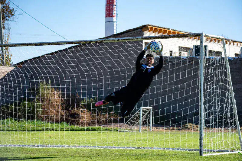 Goalkeeper makes a dramatic save during an outdoor soccer match.