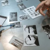 Escena de investigación con fotos de evidencia discutidas. Los oficiales analizan los detalles del sospechoso.