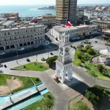 A stunning aerial view of the Clock Tower in Plaza Prat, Iquique, Chile, showcasing urban architecture and coastal beauty.