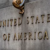Primer plano del texto «Estados Unidos de América» en un muro de piedra de estilo vintage.