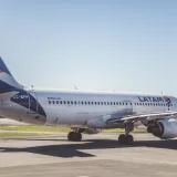 A LATAM Airlines Airbus A320 preparing for takeoff on a sunny airport runway.