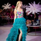 Modelo de moda con un vestido colorido caminando por la pasarela durante un vibrante desfile de moda.