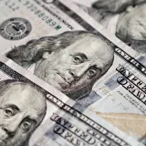 Vista detallada de varios billetes estadounidenses de cien dólares con la imagen de Benjamin Franklin.