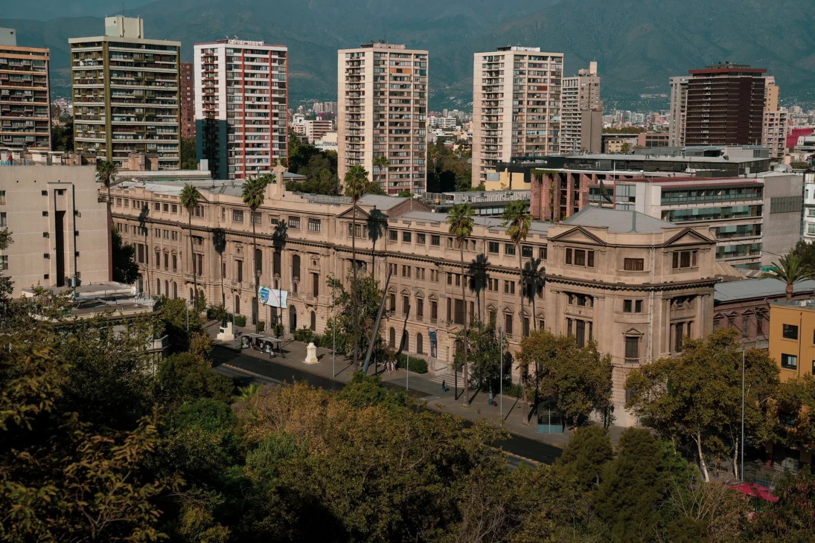 Un edificio histórico en Santiago de Chile, con modernos edificios de gran altura al fondo.