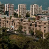 Un edificio histórico en Santiago de Chile, con modernos edificios de gran altura al fondo.