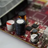 Primer plano macro detallado de una placa de circuito que destaca los condensadores, los chips y los circuitos.