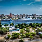 Vista panorámica de Maracaibo que muestra el edificio de la Rectoría y el horizonte de la ciudad bajo un cielo despejado.