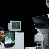 Un laboratorio futurista donde unos científicos revisan una pantalla digital y datos.