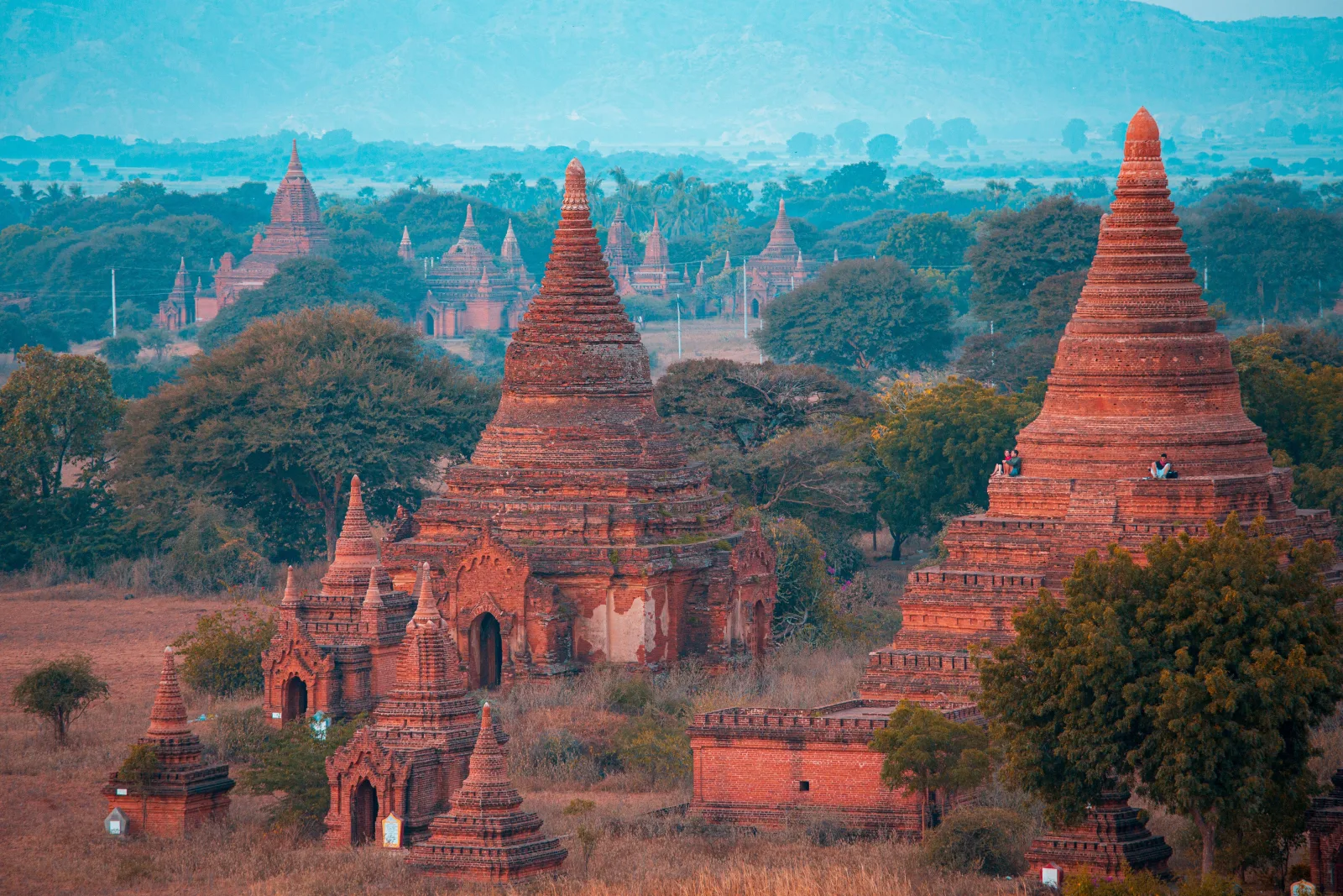 Vista aérea de las serenas estupas antiguas de la antigua Bagan, Myanmar, al amanecer, que muestra su rica historia y exuberante vegetación.