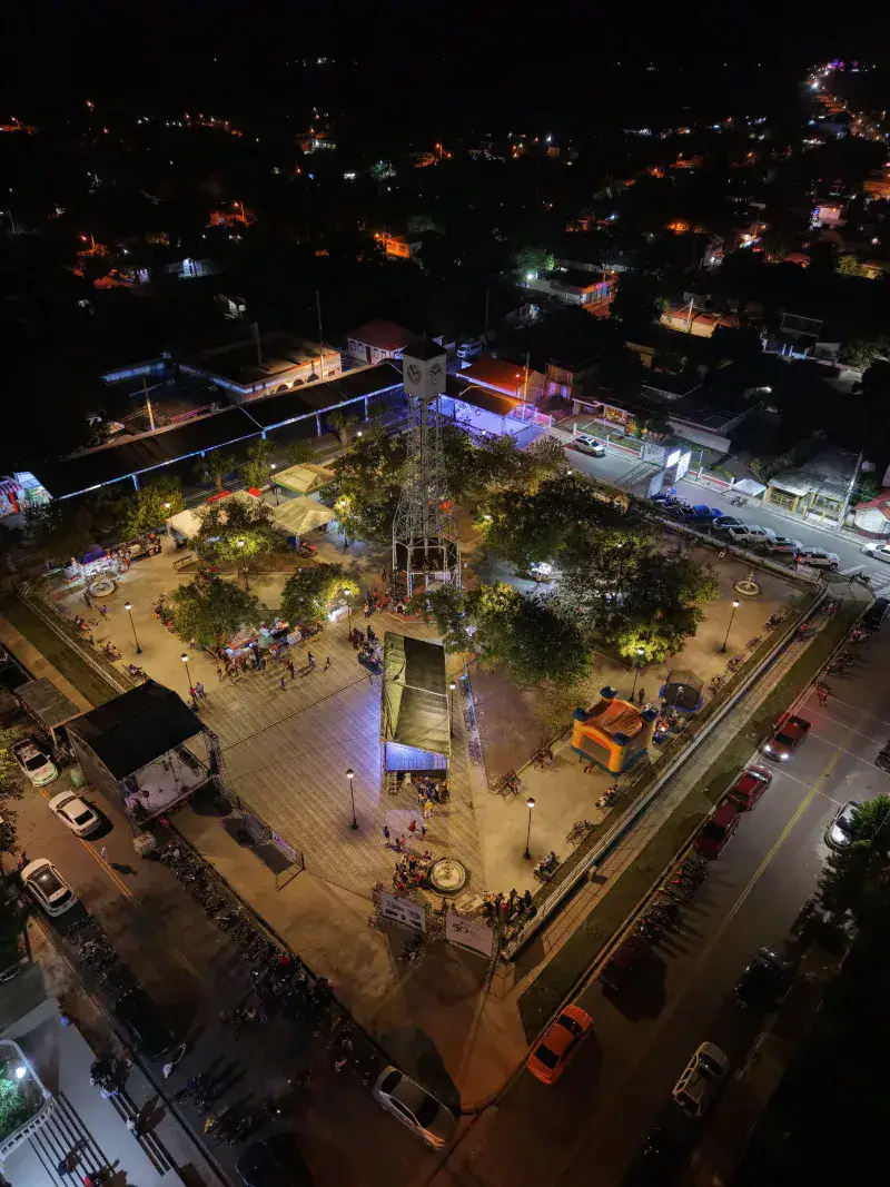 A vibrant aerial view of an illuminated plaza in Monte Cristi during the night.