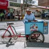 A street vendor with an ice cream cart in the lively streets of Trujillo, Peru.