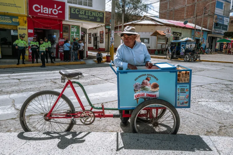 A street vendor with an ice cream cart in the lively streets of Trujillo, Peru.