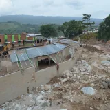 Paisaje erosionado en Mocoa, Colombia, que muestra la devastación rural y los edificios afectados por el desastre natural.