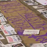 Protest signs laid on the pavement, highlighting messages of unity and social justice.