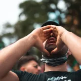 Un hombre grita apasionadamente durante una protesta al aire libre, mostrando activismo y compromiso.
