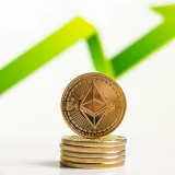 Monedas de Ethereum apiladas con una flecha ascendente que indica el crecimiento en el mercado de las monedas digitales.