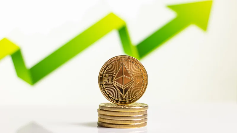 Monedas de Ethereum apiladas con una flecha ascendente que indica el crecimiento en el mercado de las monedas digitales.
