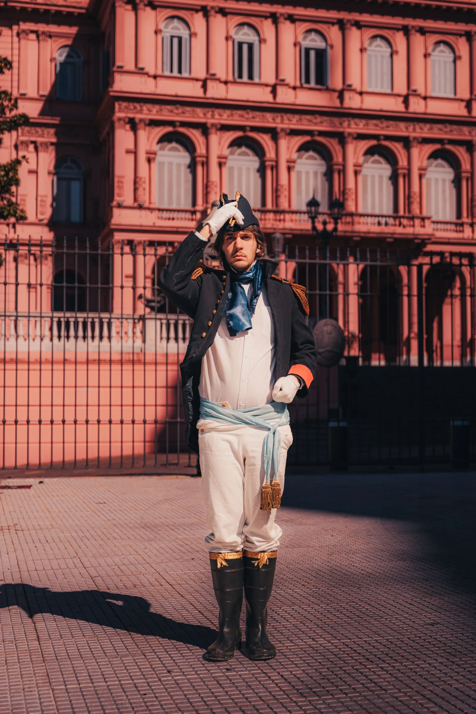Un recreador histórico vestido con indumentaria militar tradicional en la emblemática Casa Rosada de Buenos Aires, Argentina.