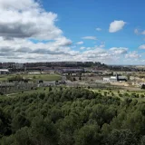 Aerial view of Valladolid, Castile and León, Spain featuring lush greenery and urban backdrop under a bright sky.